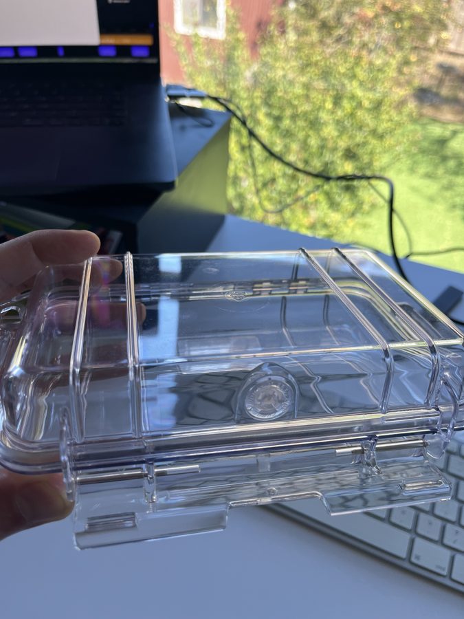An empty clear waterproof case held in a hand
