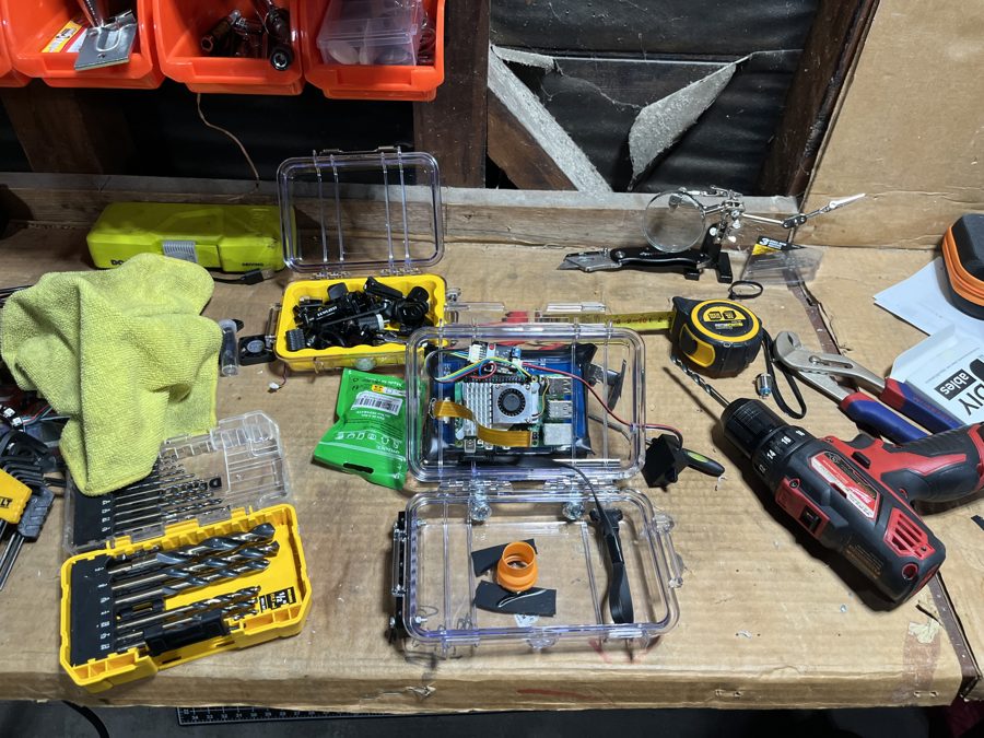 The case open on a workbench among drills and tools