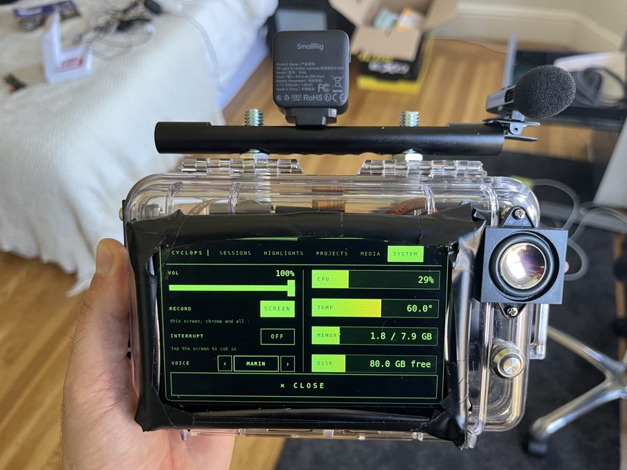 The finished case held in a hand, its screen lit up with a camera and microphone on top