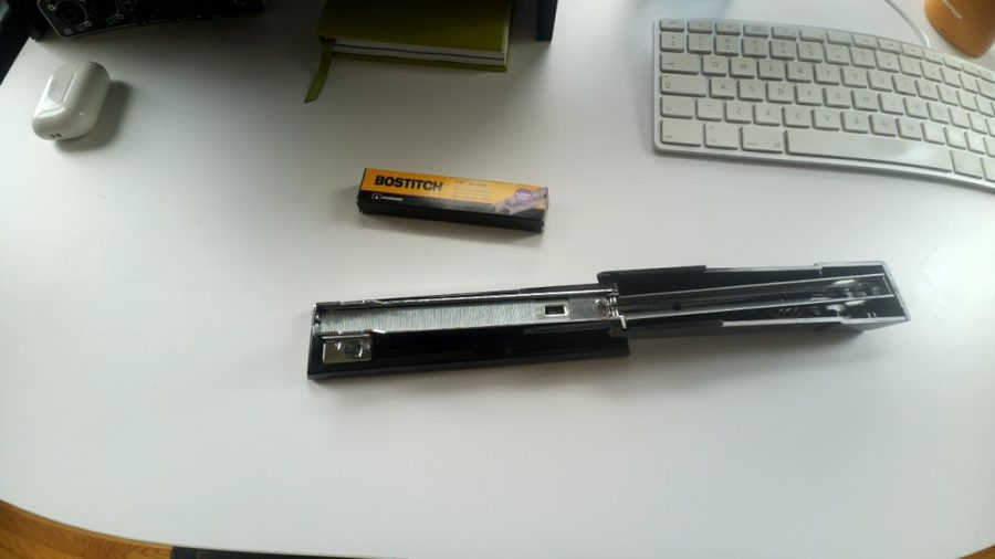 An open stapler on a desk